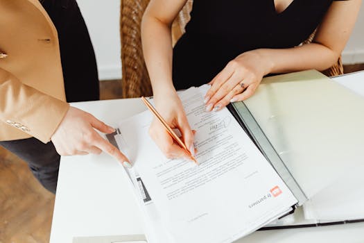 stack of documents with a pen on top