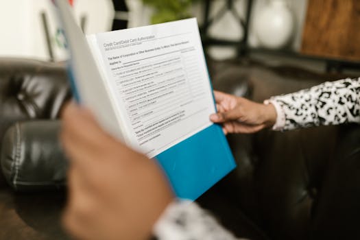 Hands typing on a calculator with tax documents